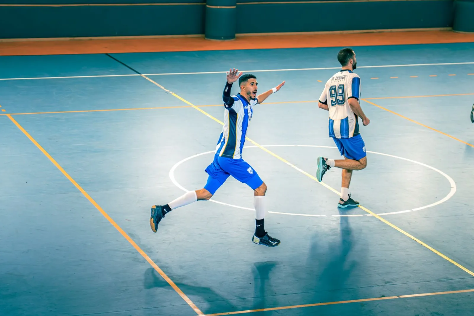 Futsal-pelaajat juoksevat sisäkentällä ottelun aikana