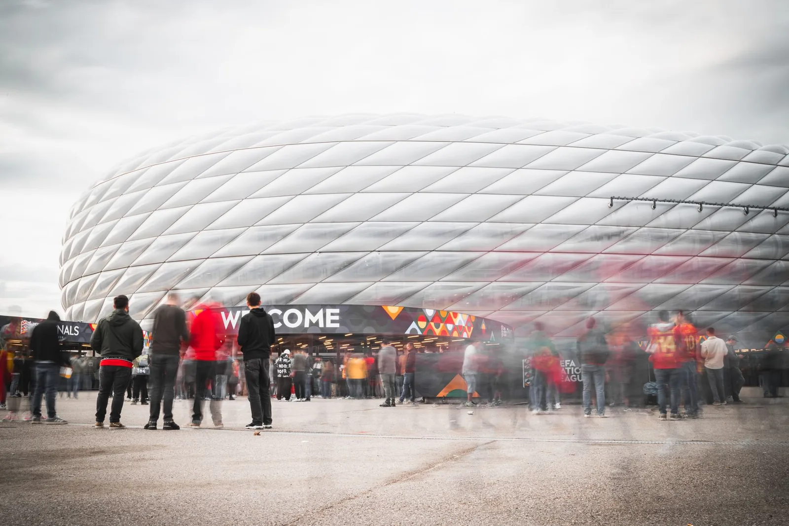 Ihmisiä stadionin ulkopuolella ottelupäivänä valkoisen areenan edessä