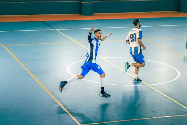 Futsal-pelaajat juoksevat sisäkentällä ottelun aikana